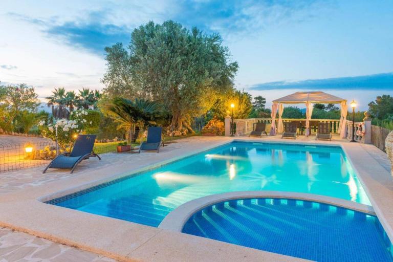 A Pool With A Gazebo And Chairs