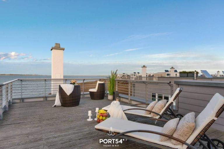 A Deck With Chairs And A View Of The Ocean