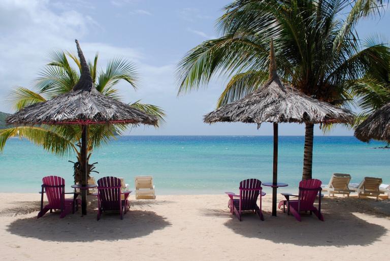 A Beach With Chairs And Umbrellas