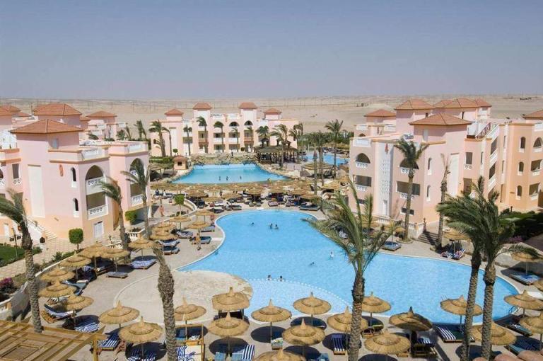 A Pool With Umbrellas And Palm Trees