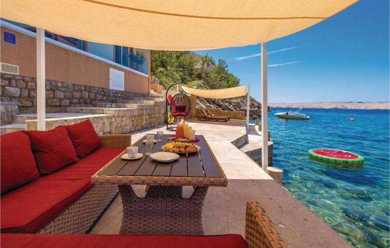 A Table And Chairs On A Patio Overlooking A Body Of Water