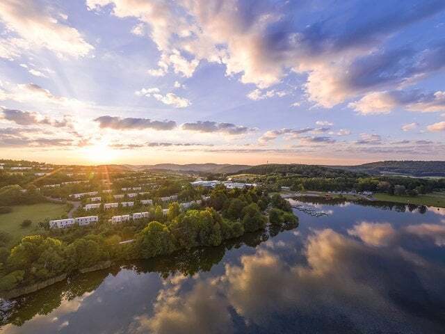 A Body Of Water With Buildings And Trees