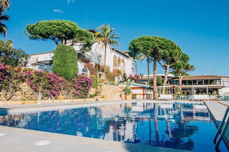 A Pool With Trees And A Building In The Background