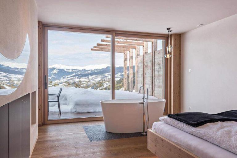 A Room With A Tub And A Bed And A Window