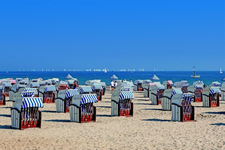 A Group Of Beach Chairs With Striped Umbrellas On A Beach