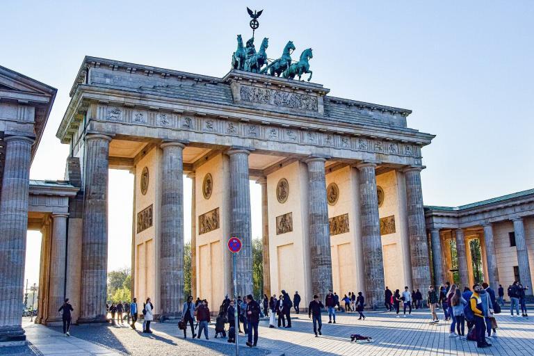 A Large Stone Structure With Columns And Horses On Top With Brandenburg Gate In The Background