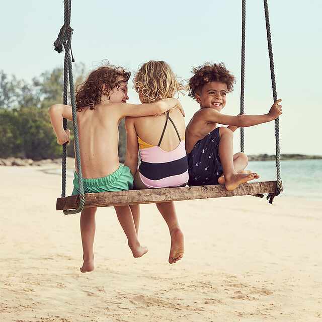 A Group Of Children On A Swing On A Beach