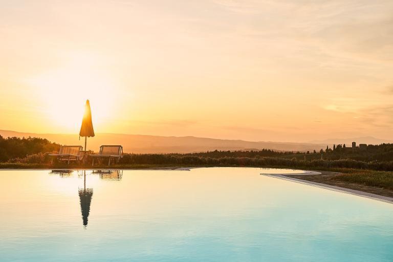 A Pool With Chairs And Umbrella In The Middle Of The Water